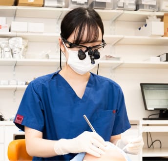 女性歯科スタッフが患者の口腔内を検査